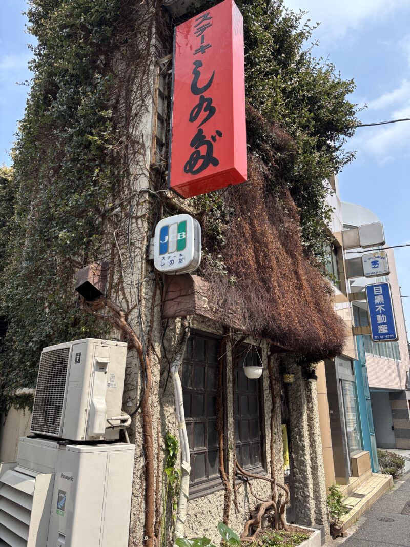 湯島「ステーキしのだ」壁を覆い尽くすように伸びた蔦が不気味な印象を与える外観