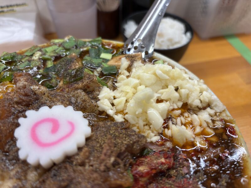 護国寺「らーめん護什番」刻みニンニクと花山椒を交互にスープに混ぜ合わせて変化を楽しむ