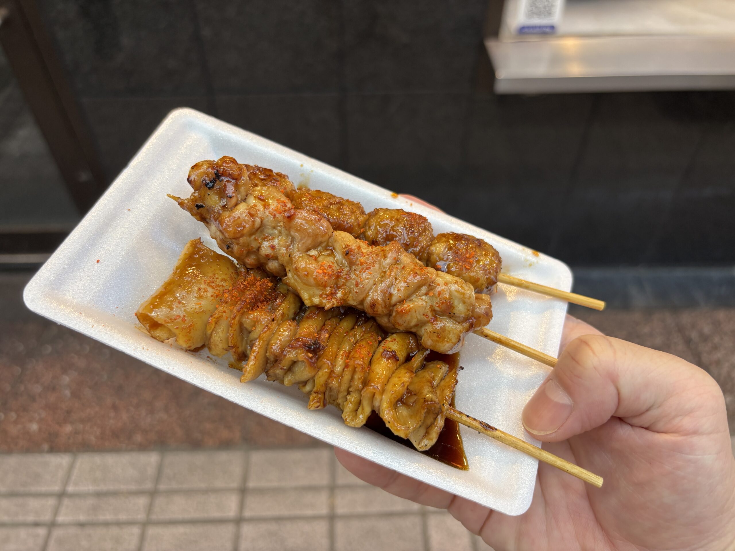 武蔵小山「鳥勇」ヒナ肉・つくね・皮の3本をチョイスしてタレを付けて白い発泡皿に盛る独自のスタイル